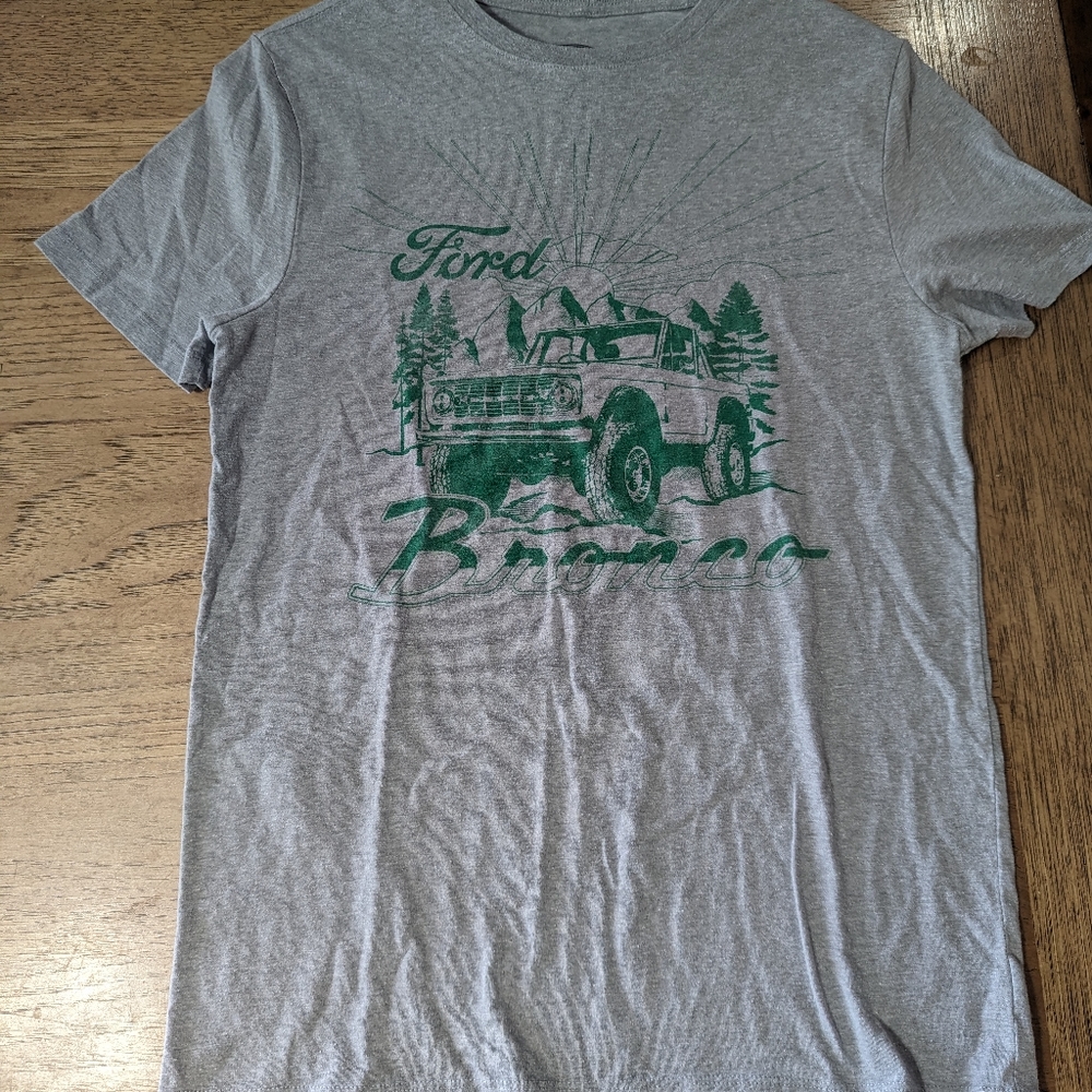 Grey Ford Bronco with nature with green font small
